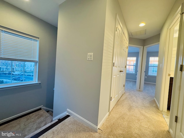 corridor featuring light colored carpet