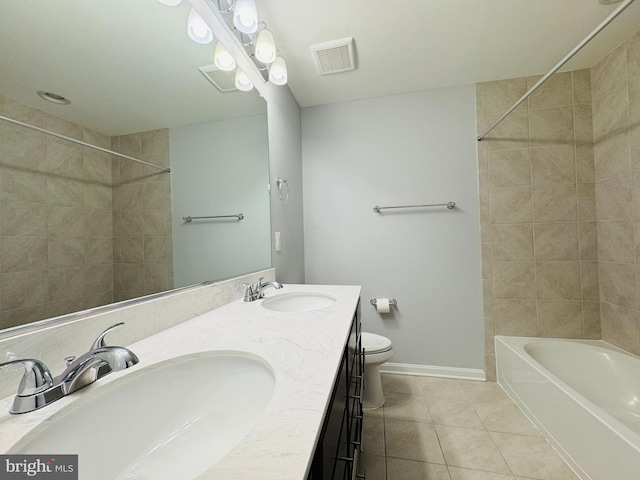 full bathroom with tile patterned flooring, vanity, tiled shower / bath combo, and toilet