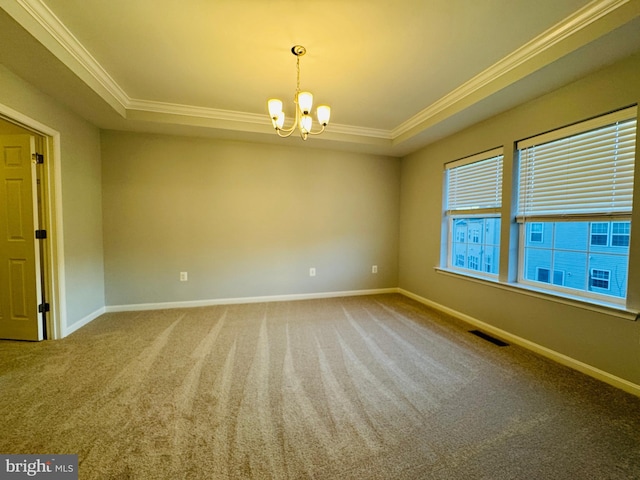 carpeted empty room with crown molding, a chandelier, and a tray ceiling