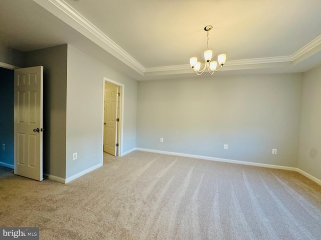 unfurnished room featuring a notable chandelier, a tray ceiling, ornamental molding, and light colored carpet