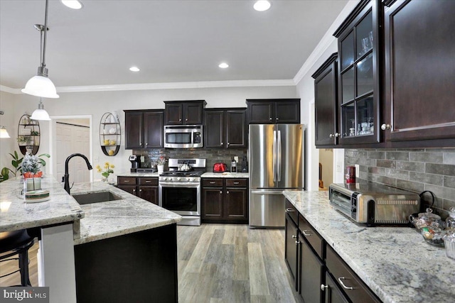 kitchen featuring appliances with stainless steel finishes, decorative backsplash, hanging light fixtures, and sink