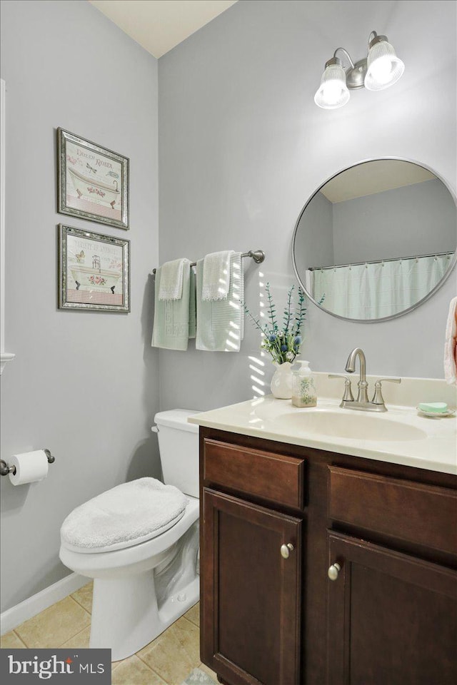 bathroom featuring toilet, vanity, and tile patterned flooring