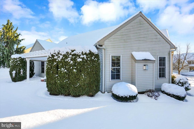 snow covered property with a pergola