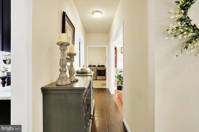 corridor with washer and dryer and dark hardwood / wood-style floors