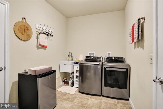 laundry room featuring light tile patterned floors, sink, and washing machine and clothes dryer