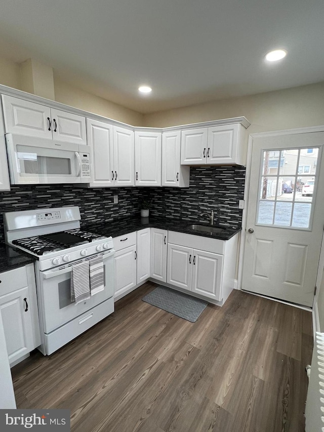 kitchen with sink, white cabinetry, tasteful backsplash, dark hardwood / wood-style floors, and white appliances