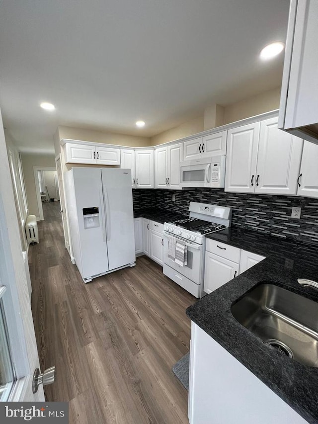 kitchen featuring tasteful backsplash, sink, white cabinets, and white appliances