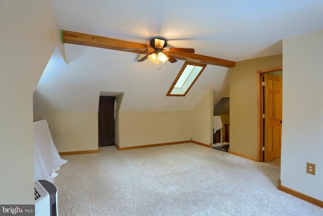 bonus room with ceiling fan, light colored carpet, and vaulted ceiling with skylight