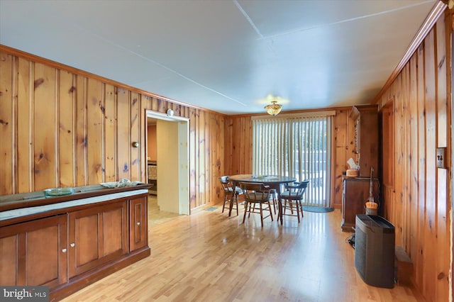 dining area featuring light hardwood / wood-style floors and wood walls