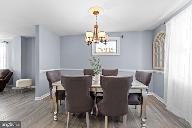 dining room with light wood-type flooring and an inviting chandelier