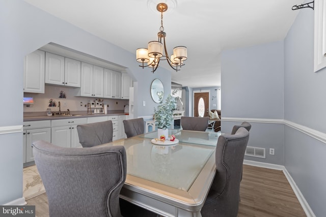 dining area with sink and a chandelier