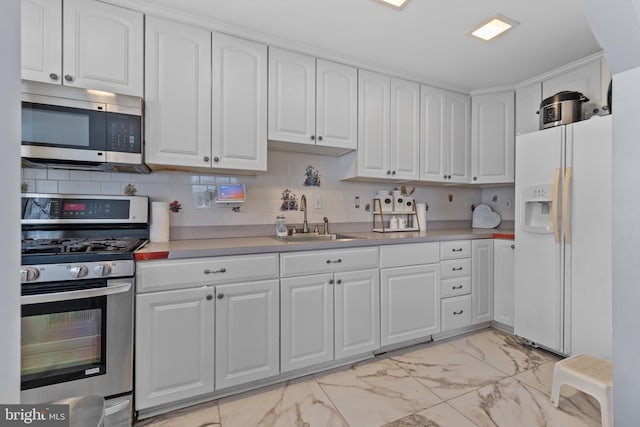 kitchen with sink, white cabinets, and appliances with stainless steel finishes