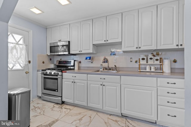 kitchen featuring sink, backsplash, white cabinets, and stainless steel appliances