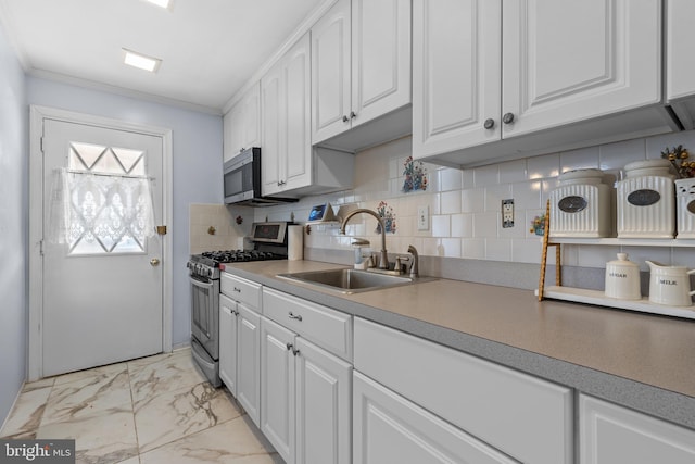 kitchen with sink, backsplash, white cabinetry, ornamental molding, and stainless steel appliances