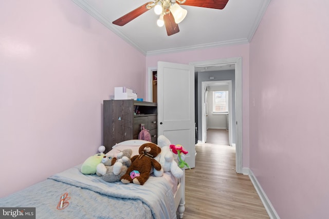 bedroom featuring light hardwood / wood-style floors, ceiling fan, and ornamental molding