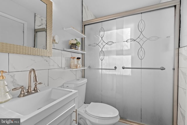 bathroom with vanity, toilet, tasteful backsplash, and a shower with shower door