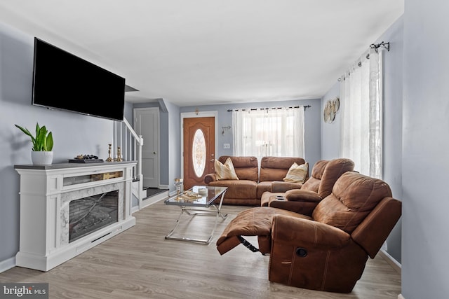 living room featuring a fireplace and light wood-type flooring