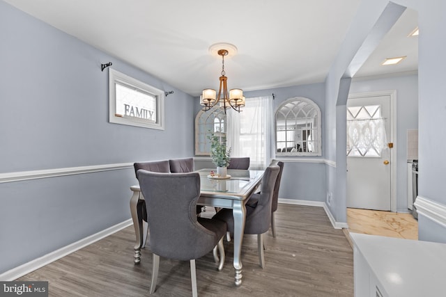 dining area featuring a notable chandelier, hardwood / wood-style floors, and plenty of natural light