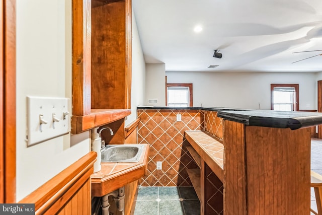 kitchen featuring tile walls, plenty of natural light, and a breakfast bar