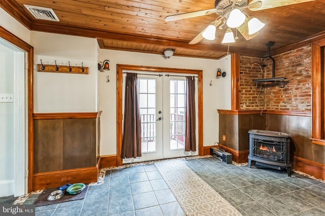 entryway with wooden ceiling, french doors, a healthy amount of sunlight, and a wood stove