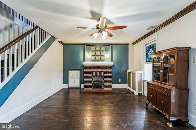 unfurnished living room featuring dark hardwood / wood-style flooring, a brick fireplace, ornamental molding, and ceiling fan