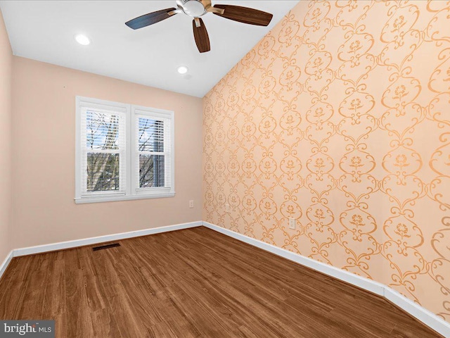 spare room with vaulted ceiling, ceiling fan, and wood-type flooring