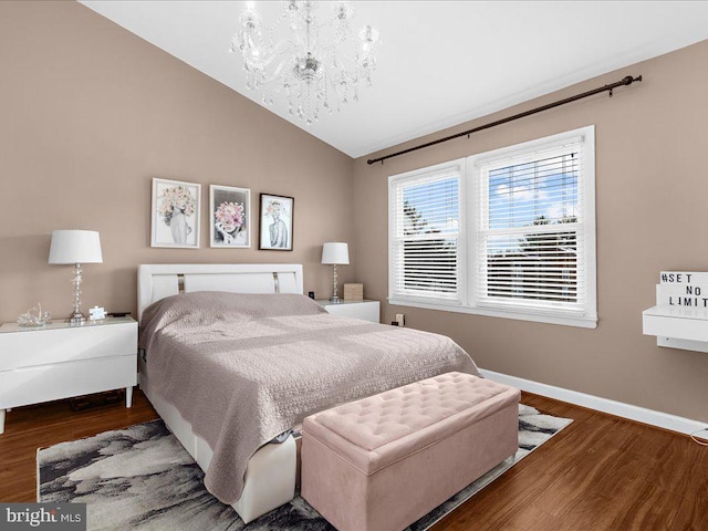 bedroom with dark hardwood / wood-style flooring, lofted ceiling, and a notable chandelier