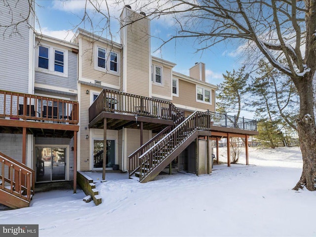 snow covered property with a deck