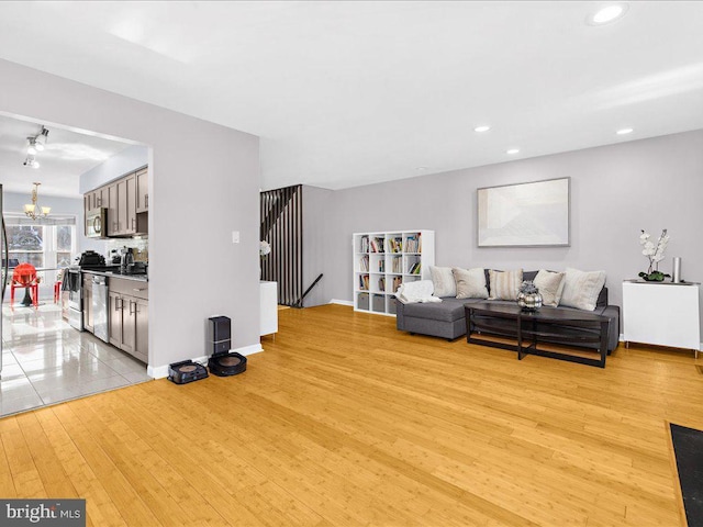 living room with an inviting chandelier and light hardwood / wood-style floors