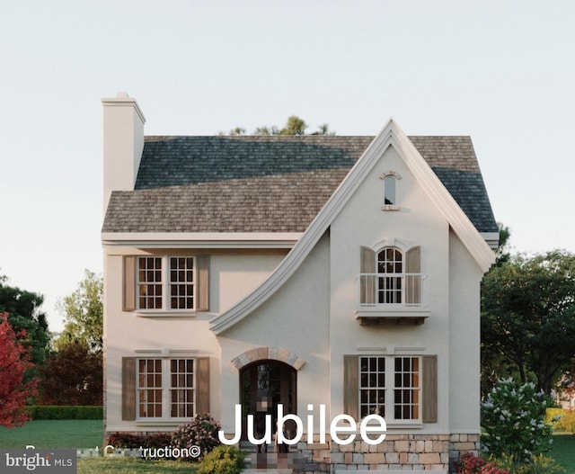 back of property with a shingled roof, a chimney, and stucco siding