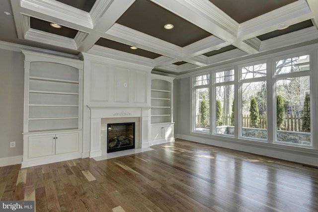 unfurnished living room with coffered ceiling, a fireplace, beam ceiling, dark wood finished floors, and crown molding