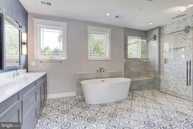 bathroom with a freestanding tub, a tile shower, and a wealth of natural light