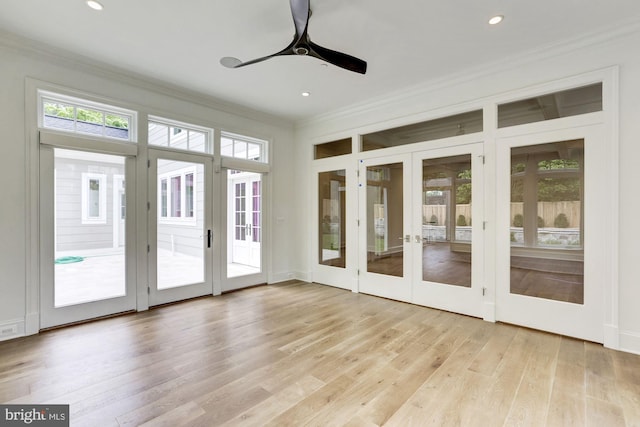 unfurnished sunroom featuring ceiling fan and french doors