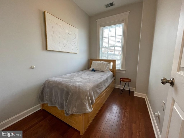 bedroom with dark hardwood / wood-style flooring