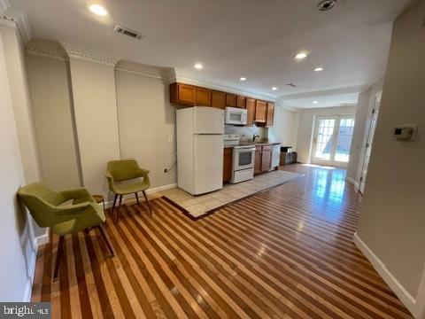 kitchen featuring crown molding and white appliances