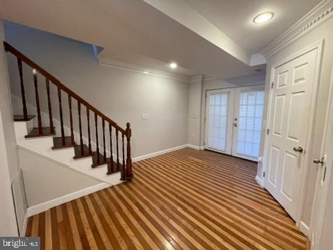 entrance foyer featuring french doors, ornamental molding, and carpet flooring