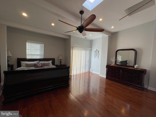 bedroom featuring dark hardwood / wood-style flooring, multiple windows, lofted ceiling with skylight, and ceiling fan