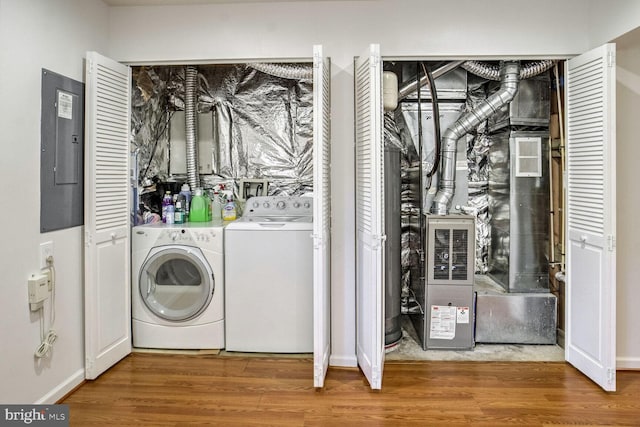 clothes washing area with separate washer and dryer, hardwood / wood-style floors, and electric panel