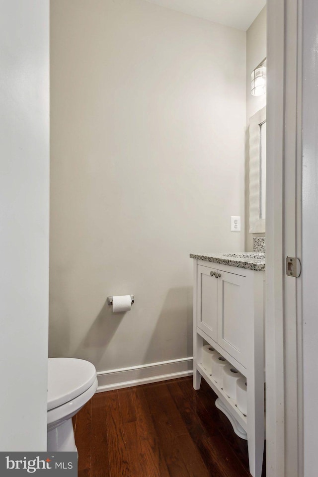 bathroom featuring vanity, hardwood / wood-style flooring, and toilet