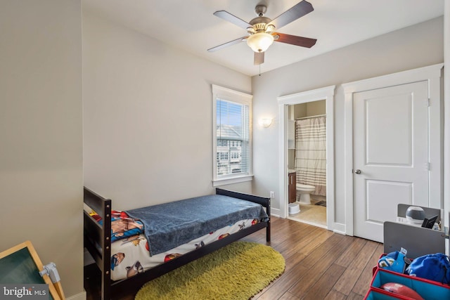 bedroom featuring ceiling fan, connected bathroom, and dark hardwood / wood-style flooring