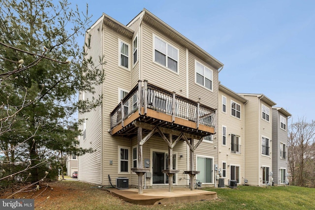 rear view of house featuring central AC unit, a yard, and a patio area