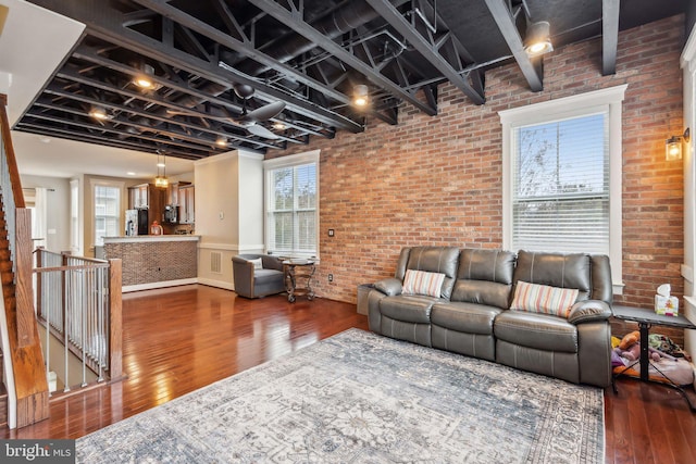 living room featuring hardwood / wood-style flooring and brick wall