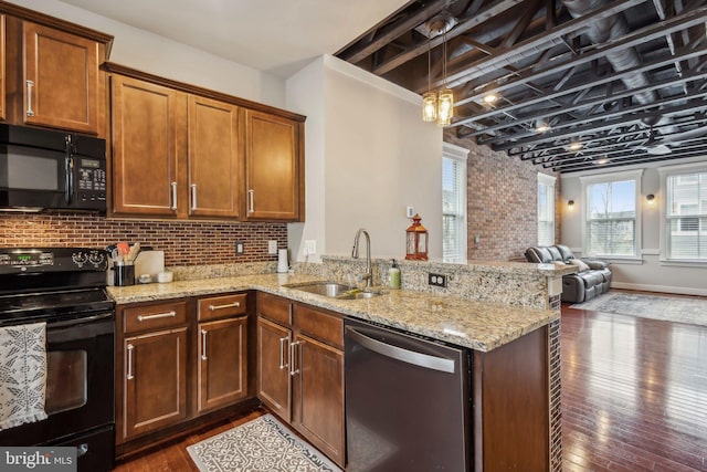 kitchen featuring dark hardwood / wood-style flooring, kitchen peninsula, sink, and black appliances