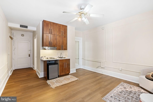 kitchen featuring ceiling fan, sink, white stovetop, and light hardwood / wood-style floors