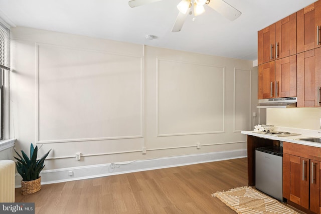 kitchen featuring white electric cooktop, radiator heating unit, dishwashing machine, and light hardwood / wood-style floors