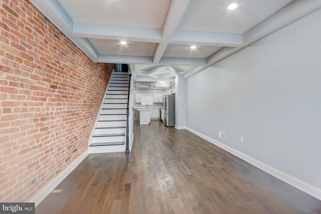 basement featuring sink, brick wall, stainless steel fridge, and dark hardwood / wood-style flooring