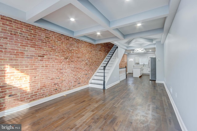 basement featuring dark wood-type flooring, brick wall, and stainless steel fridge