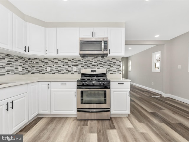 kitchen featuring stainless steel appliances, light hardwood / wood-style floors, and white cabinets