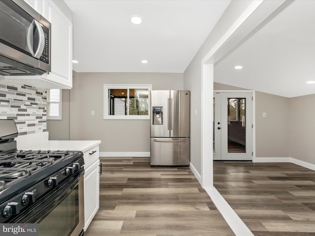 kitchen featuring decorative backsplash, white cabinetry, and appliances with stainless steel finishes