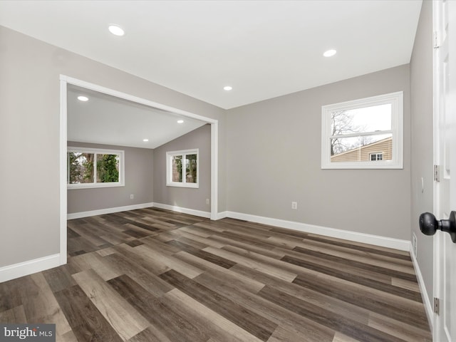 spare room featuring dark hardwood / wood-style floors and vaulted ceiling